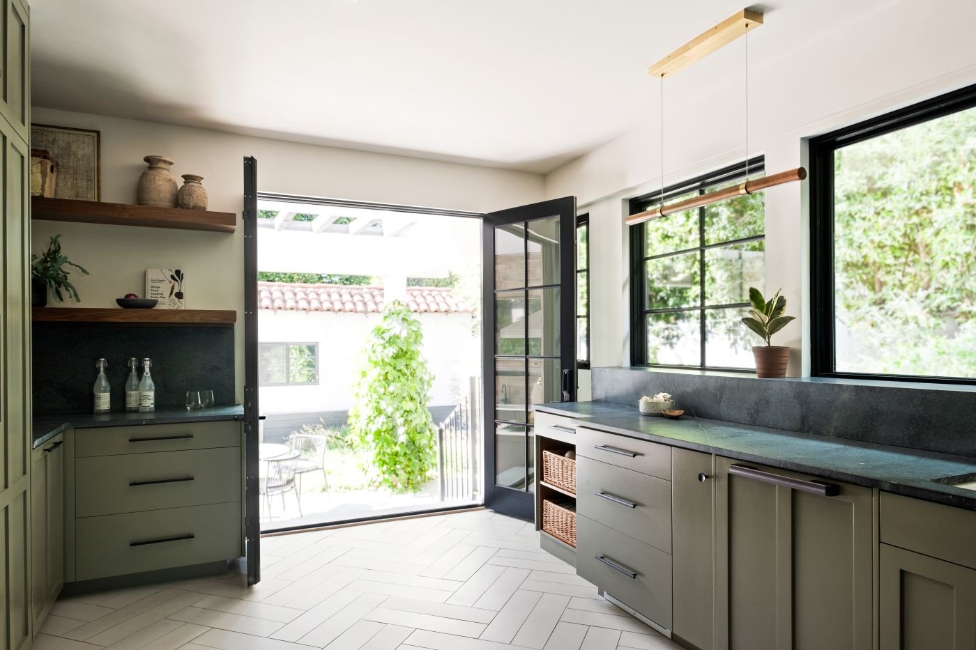 An interior shot of two closed hinged patio doors in a brightly lit kitchen.