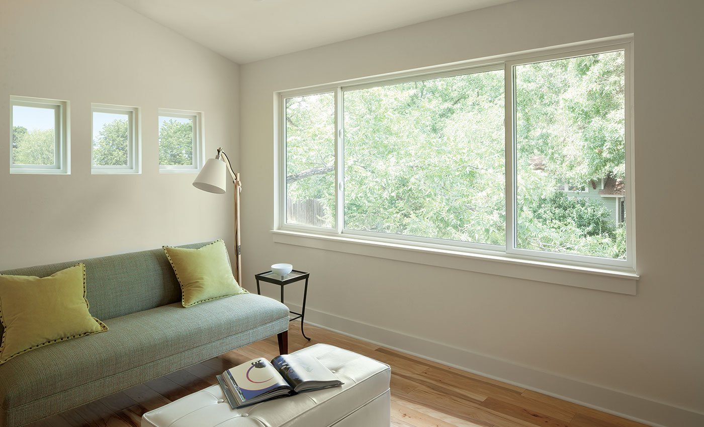 A living room with a three-sash Andersen® 100 Series Gliding Window.