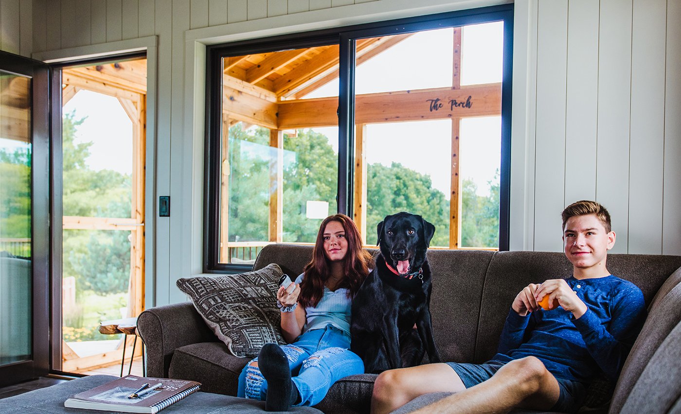A living room with an Andersen® 100 Series Gliding Windows facing the porch.