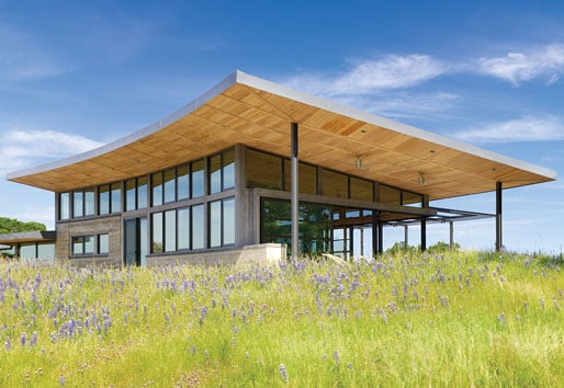 A view of the home from a distance showcasing the drama of its curved roof and generous overhangs.