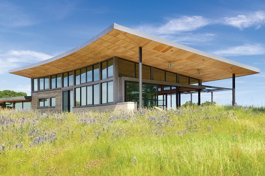 A view of the home from a distance showcasing the drama of its curved roof and generous overhangs.