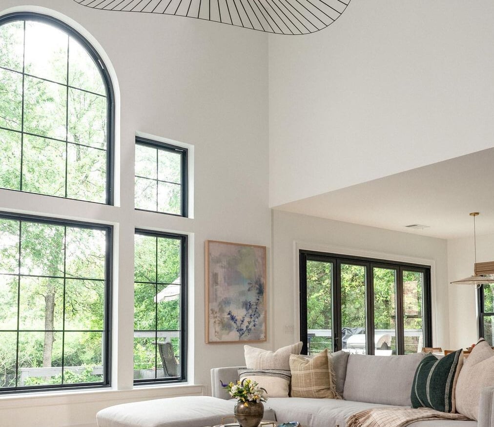A living room with a window wall featuring Andersen® 100 Series windows.