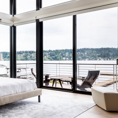 A bedroom with Andersen E-Series Gliding Doors flanked by stationary panels and topped with E-Series Picture Windows.