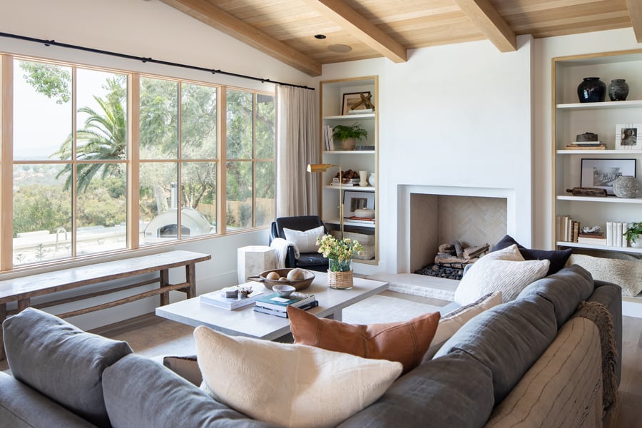 A living room with a couch facing a row of E-Series Picture Windows with white oak frames.