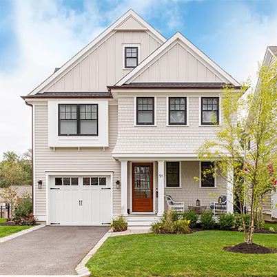 white two story house with red door and black framed Andersen windows